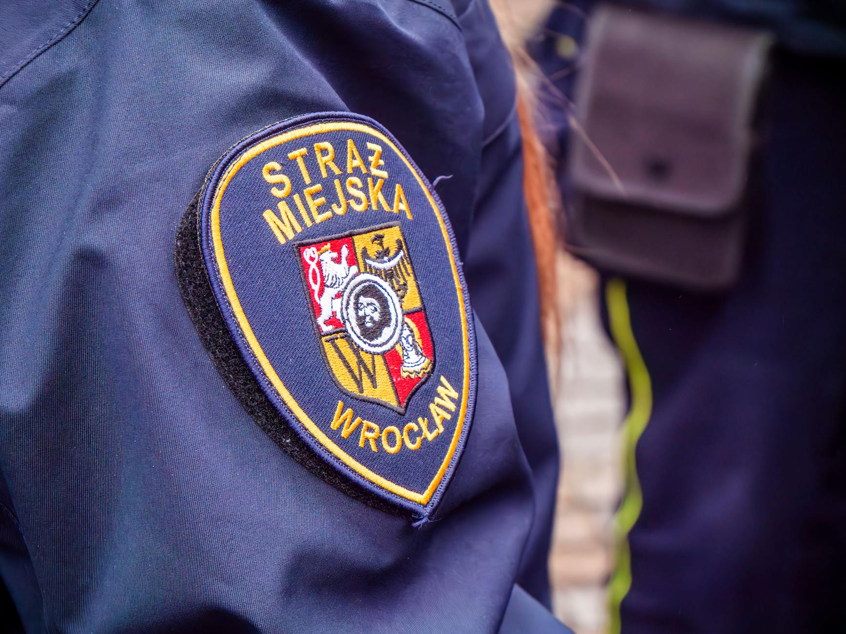 Znak drogowy informujący o bezpieczeństwie i symbol prądu w Milanówku